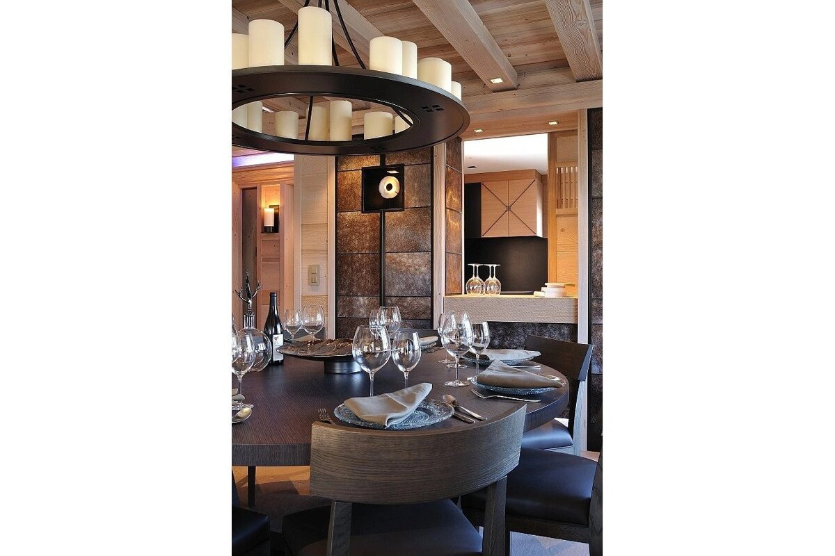A dining room table with plates and wine glasses on it