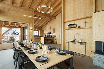A long wooden table with plates and glasses on it