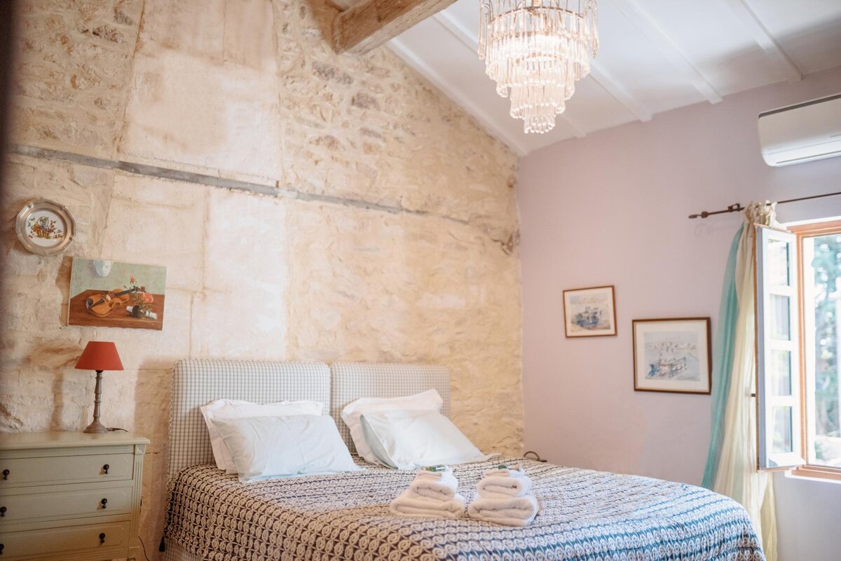 A bedroom with a chandelier hanging from the ceiling