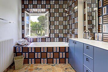 A bathroom with a geometric pattern on the wall
