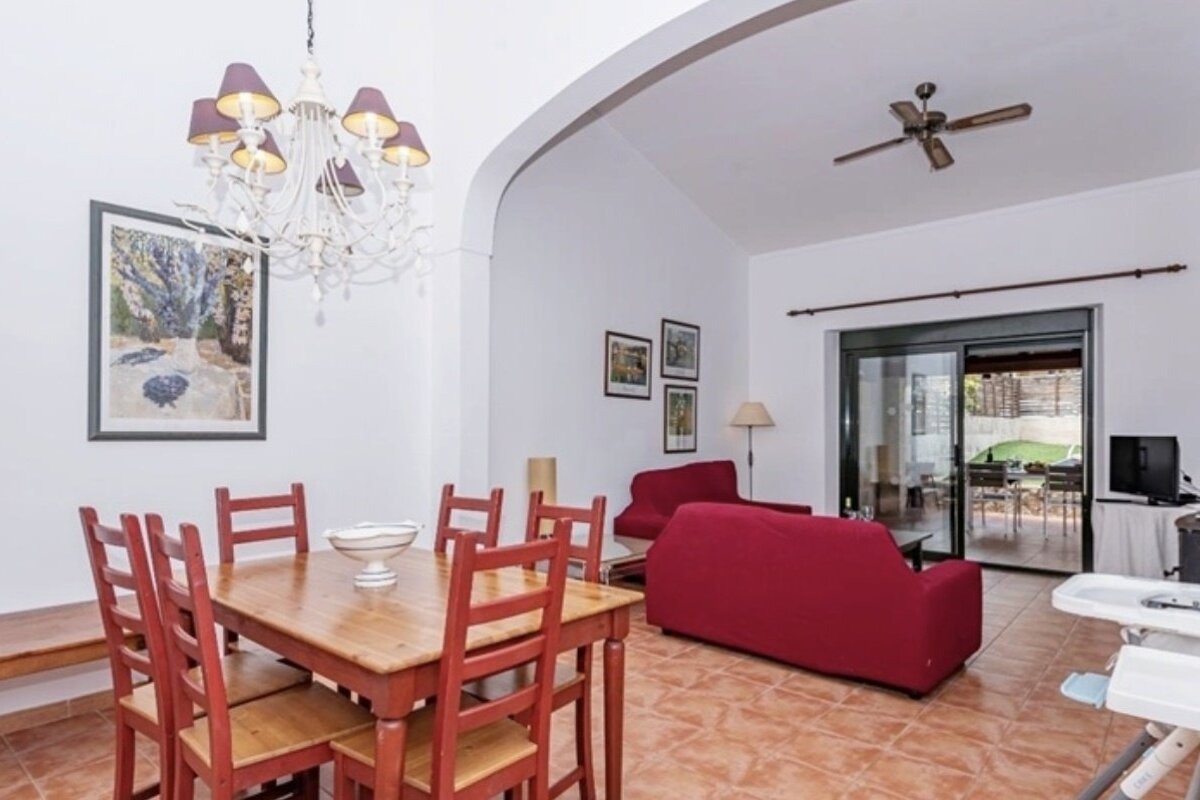 A living room with a table and chairs and a ceiling fan