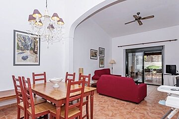 A living room with a table and chairs and a ceiling fan