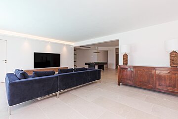 A living room with a blue couch and a flat screen tv