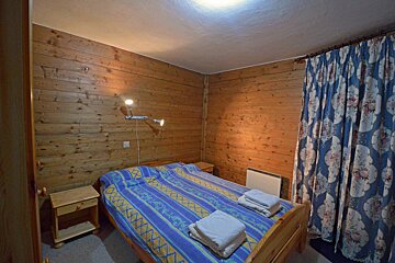 A bedroom with a blue and yellow striped bedspread