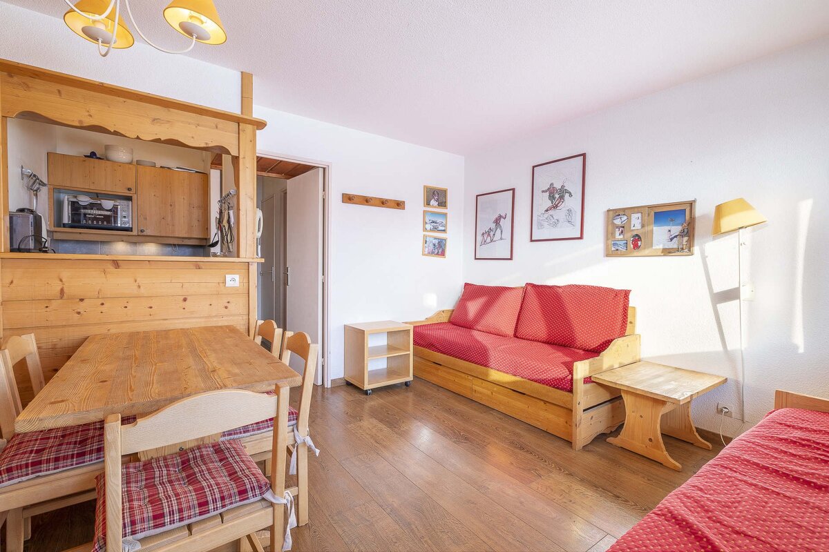 A living room with a red couch and a wooden table