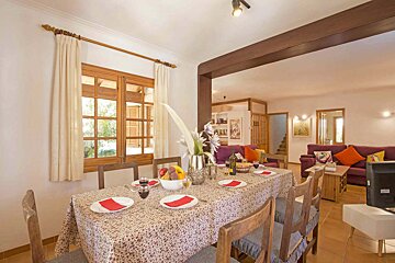 A dining room table with plates and wine glasses on it