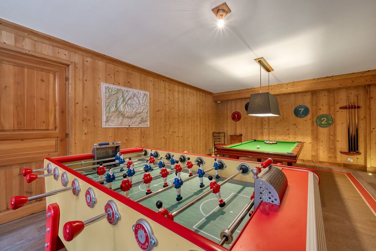 A game room with a pool table and a foosball table