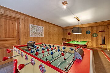 A game room with a pool table and a foosball table