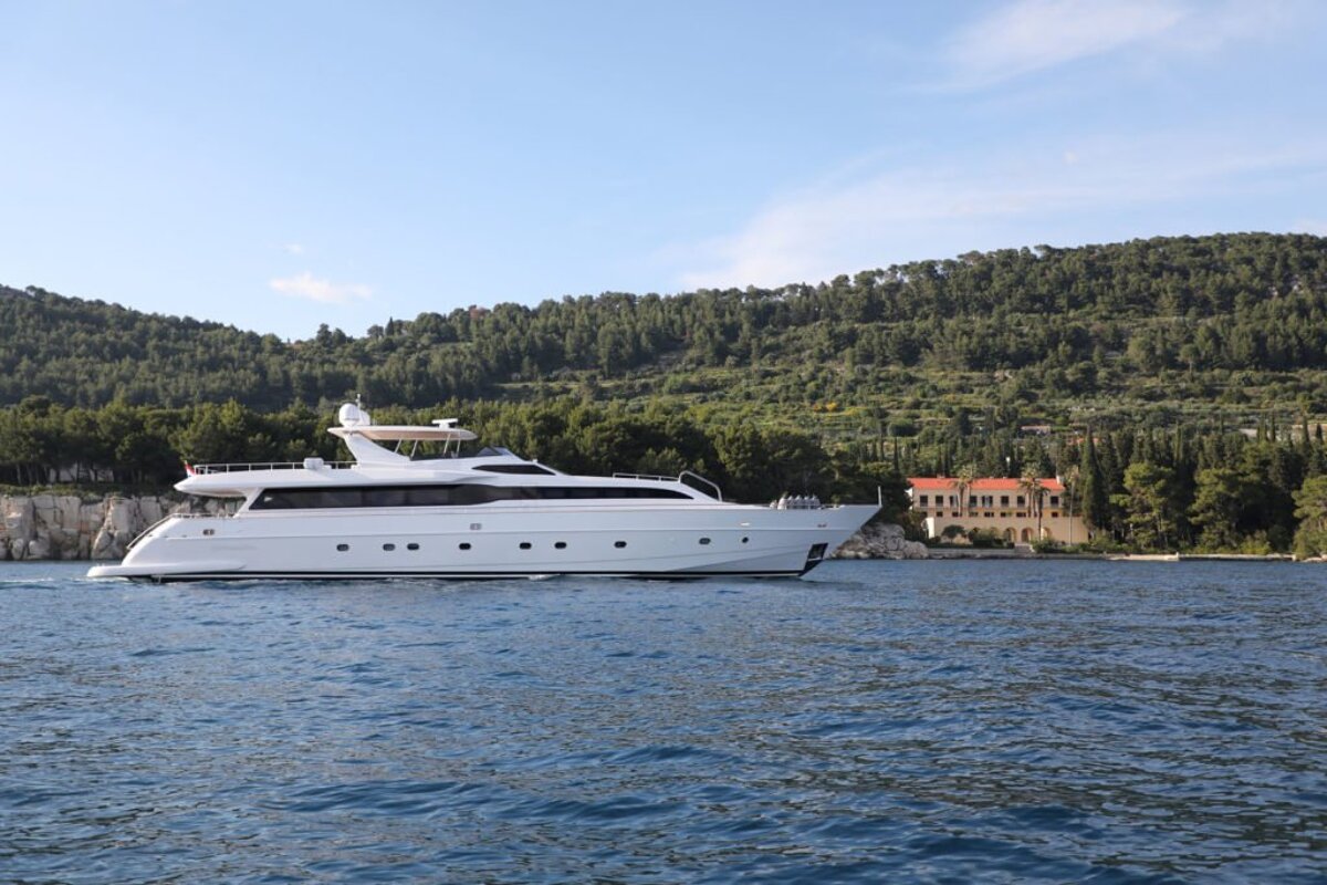 A large white yacht is floating in the water
