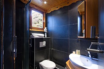 A bathroom with a toilet a sink and a window