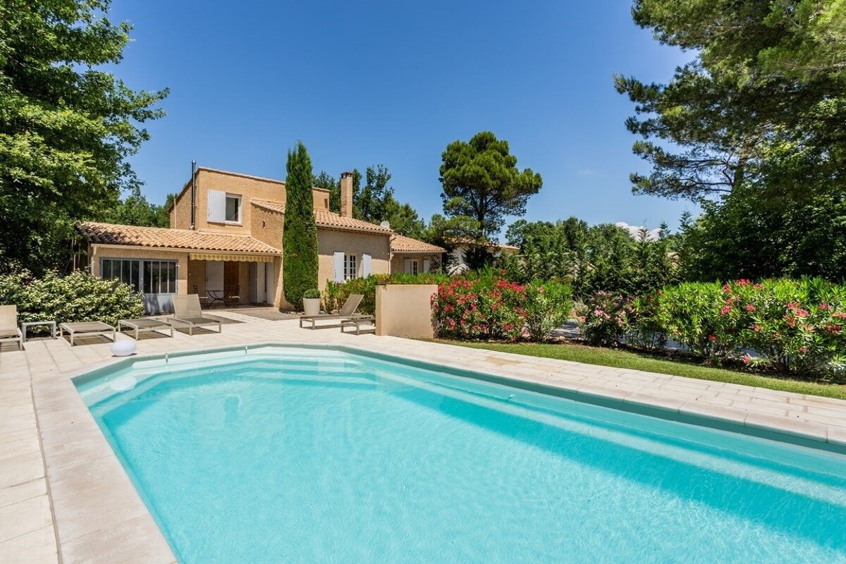 A house with a large swimming pool in front of it
