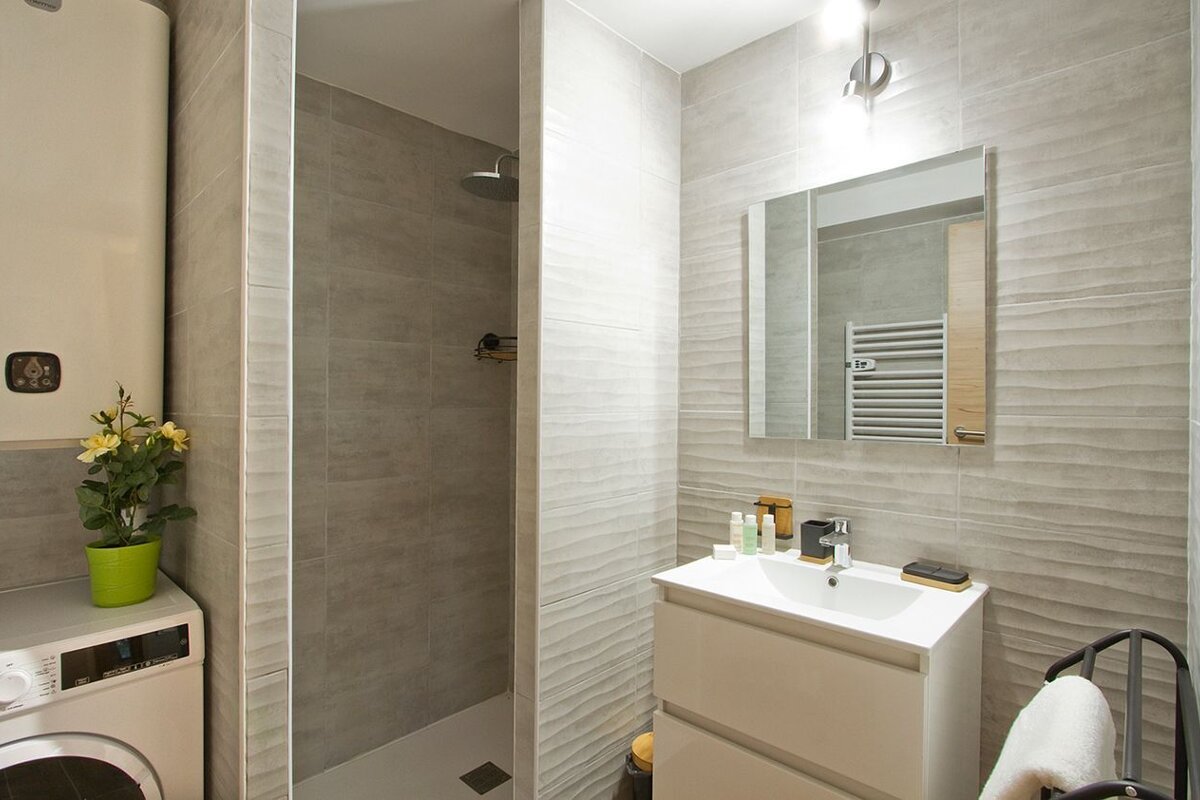A bathroom with a washing machine and a sink