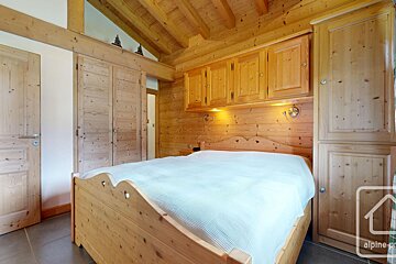 A bedroom with a bed and a sign that says alpine property