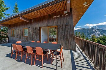 A table and chairs on a balcony with a sign that says horizon blanc