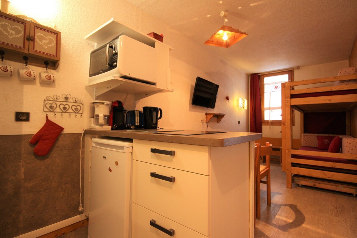 A kitchen with a small refrigerator and a microwave