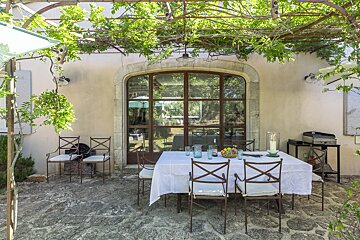 A patio with a table and chairs under a canopy