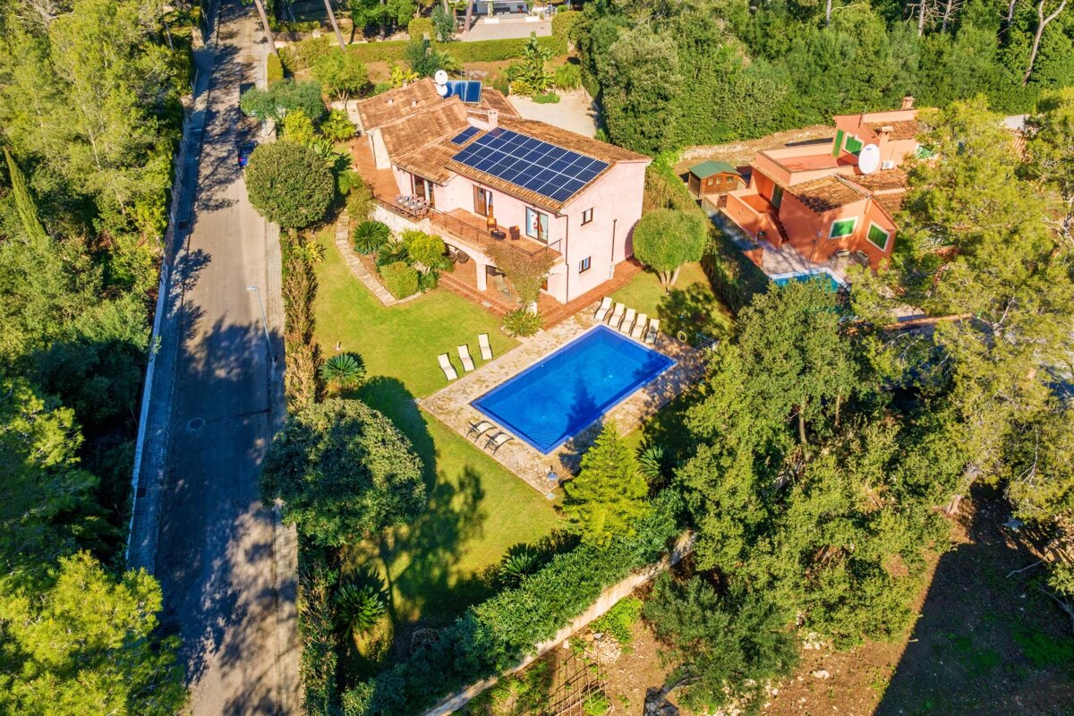 An aerial view of a house with solar panels on the roof