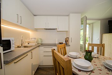 A small kitchen with white cabinets and a microwave