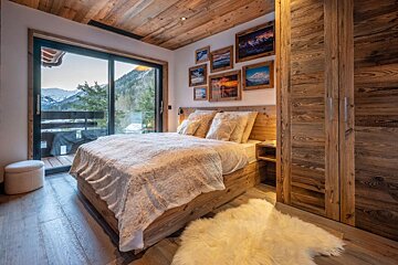 A bedroom with a bed and pictures on the wall