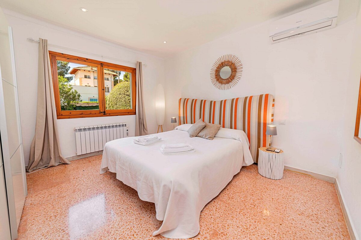 A bedroom with a large bed and a striped headboard