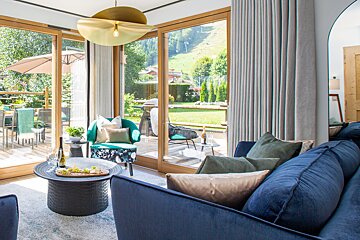 A living room with a blue couch and a green chair