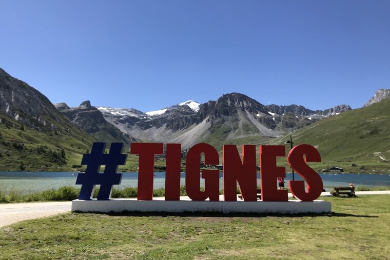 A large red and blue sign that says #tignes