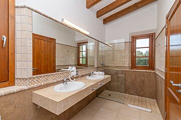 A bathroom with two sinks and a walk in shower
