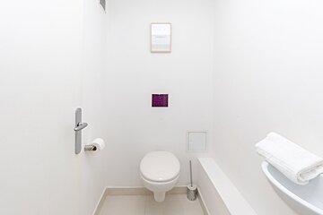 A bathroom with a toilet and a picture on the wall