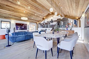 A living room with a blue couch and white chairs