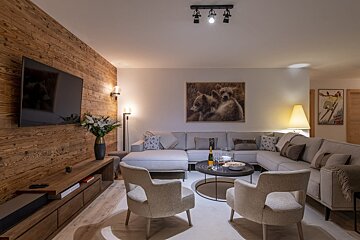 A living room with a large sectional couch and chairs