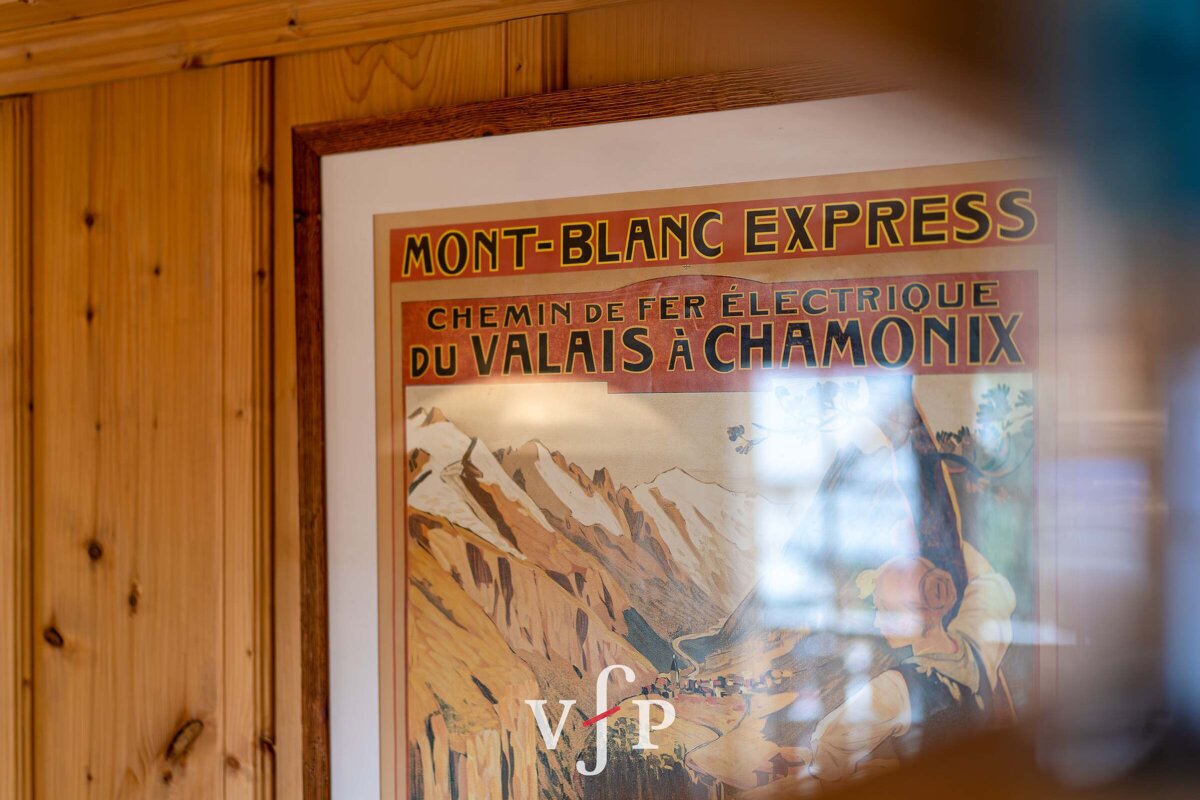 A poster for mont-blanc express hangs on a wooden wall