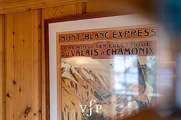 A poster for mont-blanc express hangs on a wooden wall