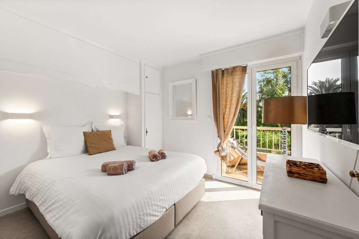 A bedroom with a large bed and a balcony