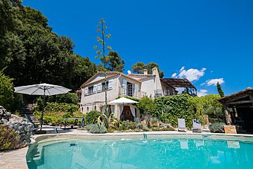 A large house with a swimming pool in front of it