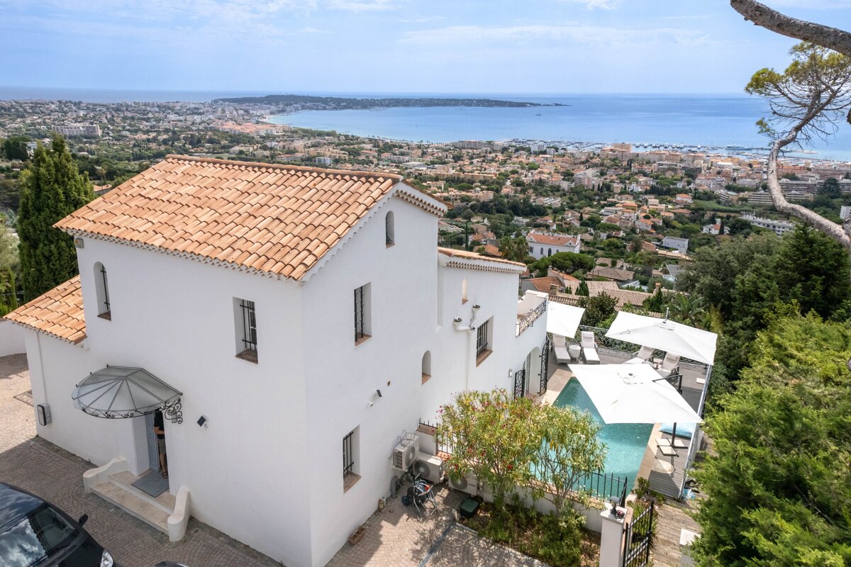 A white house with a pool and a view of the ocean