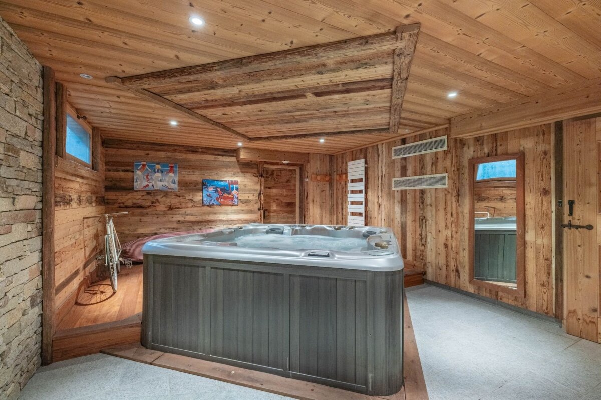A hot tub in a rustic wooden room.