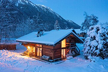 A snowy cabin with a mountain in the background
