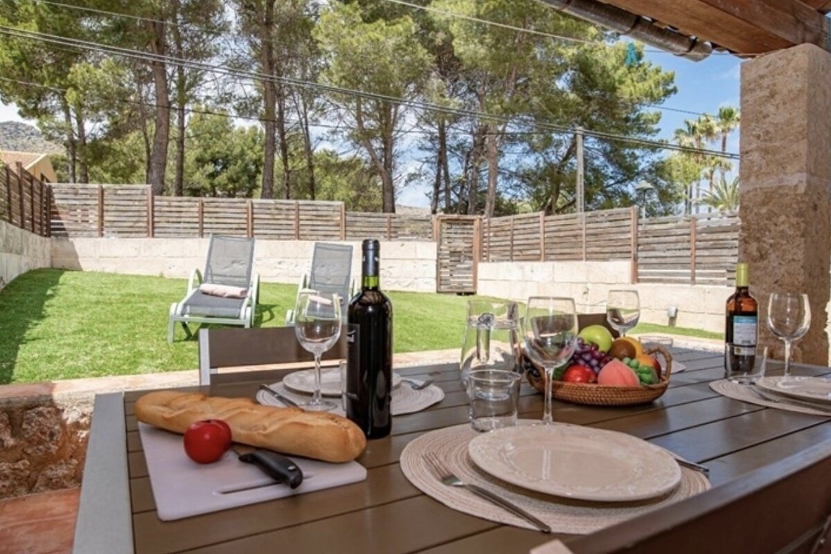 A bottle of wine sits on a table next to a loaf of bread