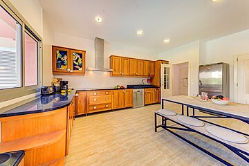 A kitchen with wooden cabinets and a black counter top