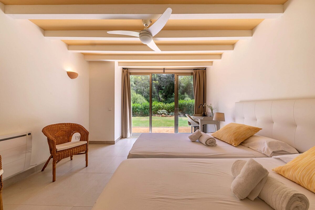 A bedroom with two beds and a ceiling fan