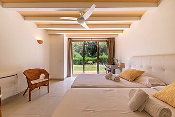 A bedroom with two beds and a ceiling fan