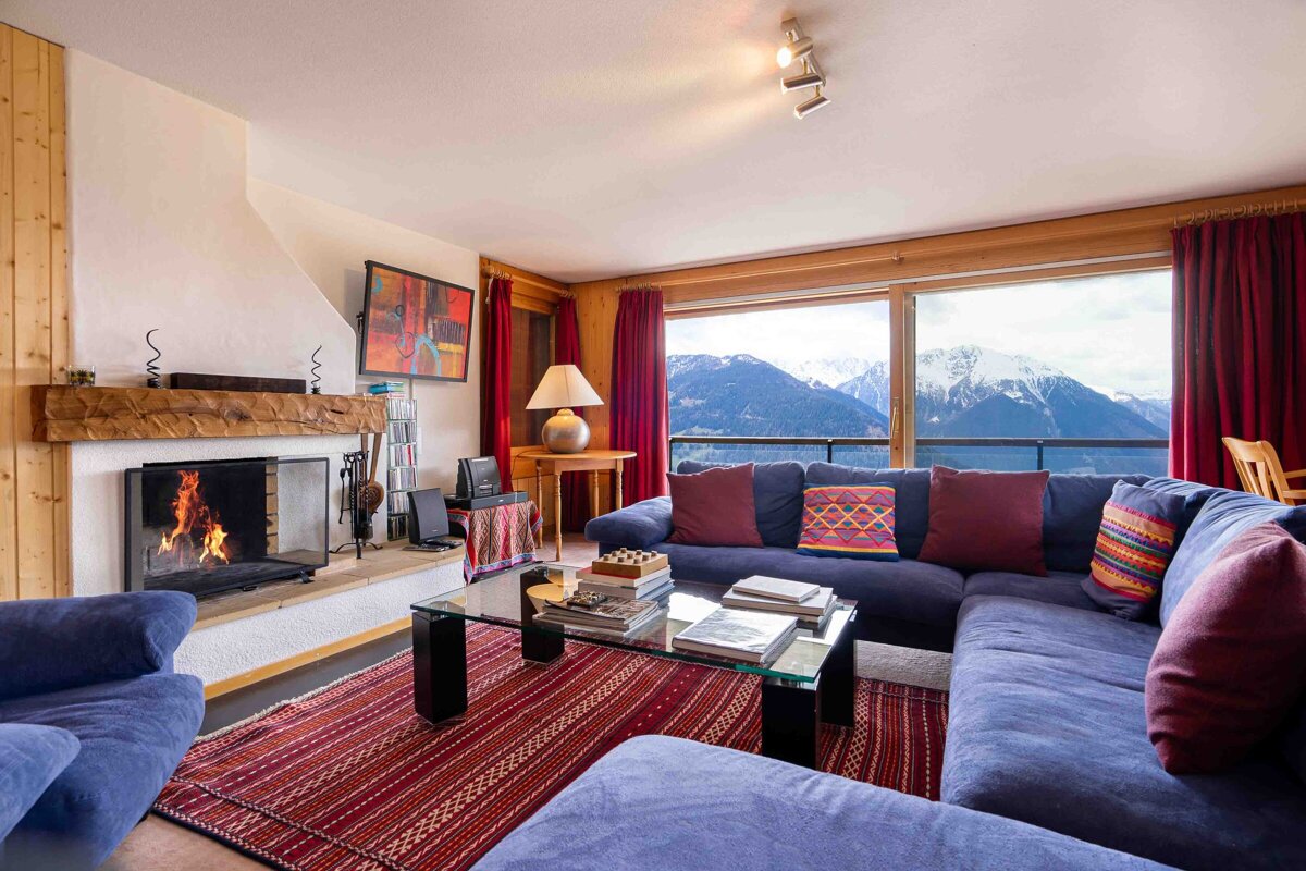 A living room with a blue couch and a fireplace