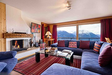 A living room with a blue couch and a fireplace