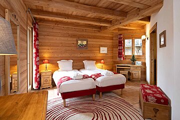 A bedroom with two twin beds and a red rug