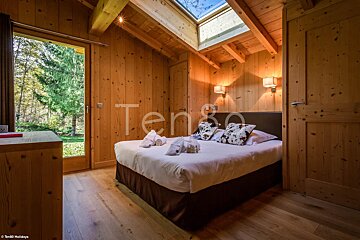 A bedroom with a bed and a skylight and the word ten on the wall