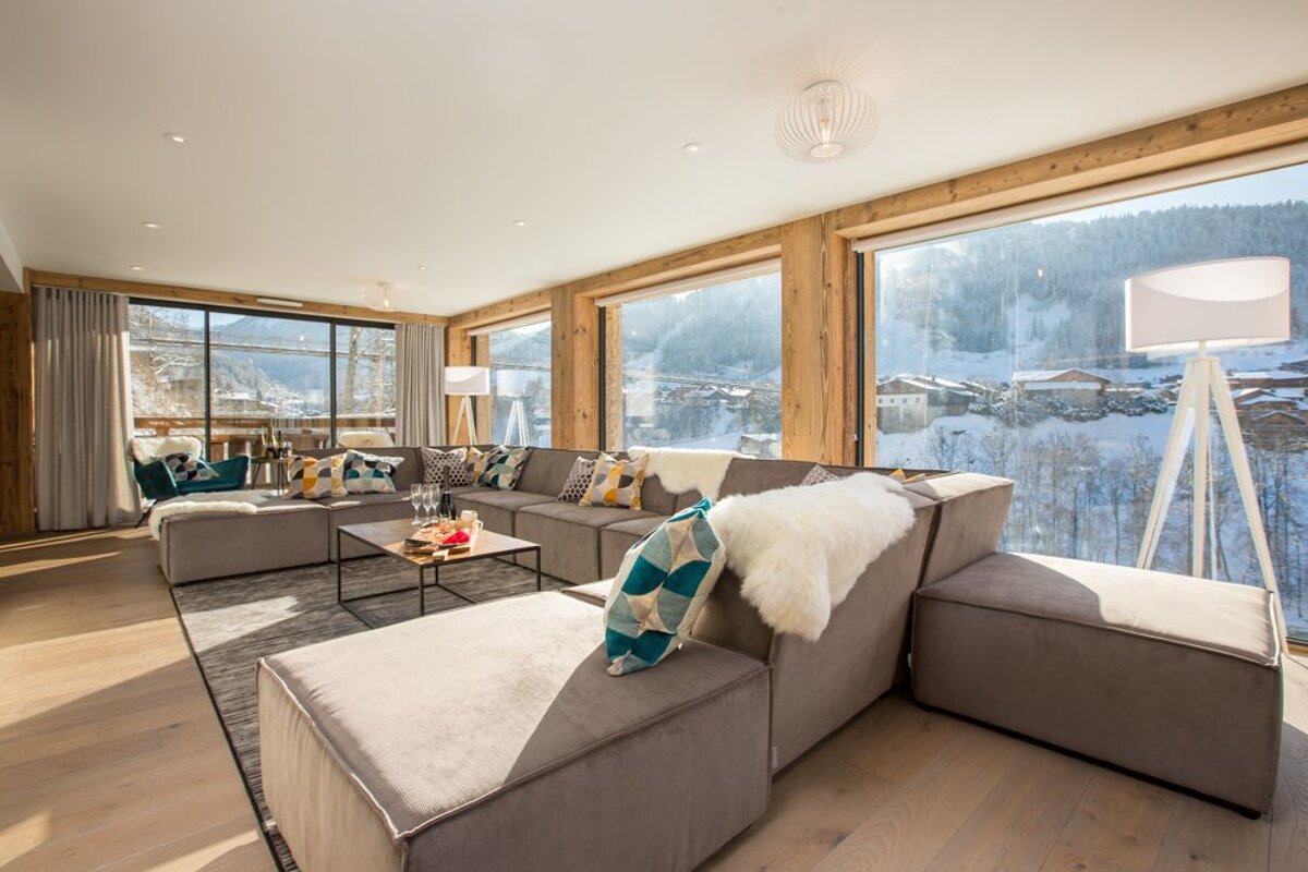 A living room filled with furniture and a view of a snowy mountain