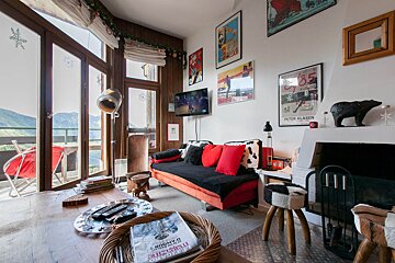 A living room with a couch and a poster that says peter klasen