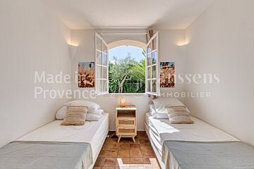 A bedroom with two beds and a window that says made in provence