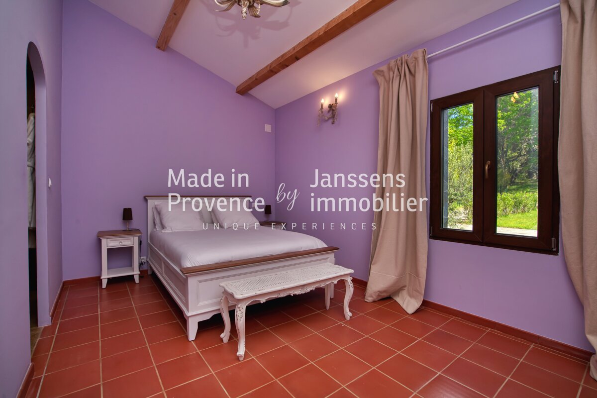A bedroom with purple walls and a bed made in provence by janssens immobilier