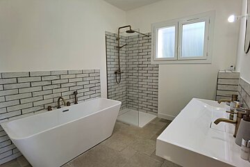 A bathroom with a bathtub and two sinks